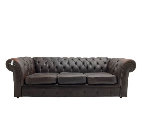 Mid-20th century three seat Chesterfield sofa, upholstered in buttoned chocolate brown leather with studwork border, on casto