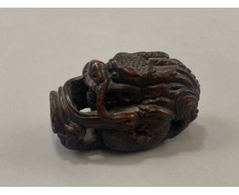 Japanese hand carved boxwood Netsuke in the form of a Foo Dragon, signed on base, L6cm x H3.5cm