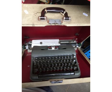 An Olympia Typewriter in case  Condition: as found, there has been a little text previously typed on this machine however, th
