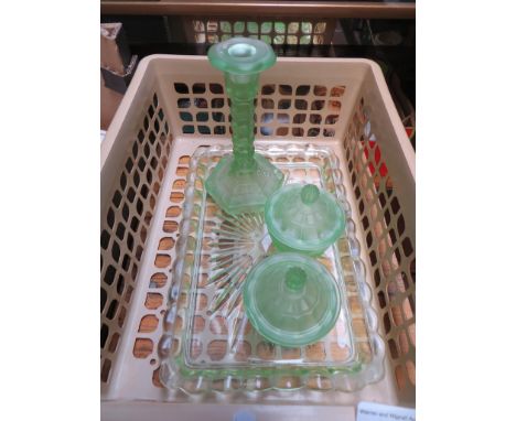 A green glass dressing table set comprising tray, two lidded trinket pots and a candlestick 