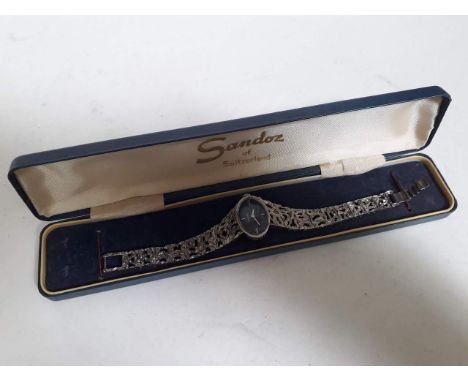 A vintage Sandoz ladies manual wind wristwatch with integrated pierced silver tone bracelet strap, comes with associated box.