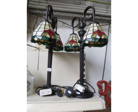 A pair of table lamps, each with twin Tiffany style shadesCondition: a small panel cracked on each lamp, otherwise good, heig