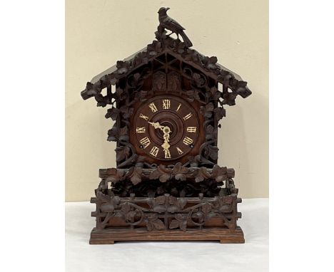 A late 19th Century Bavarian quarter striking 'Cuckoo and Quail' table clock, in chalet style oak case, the movement with goi