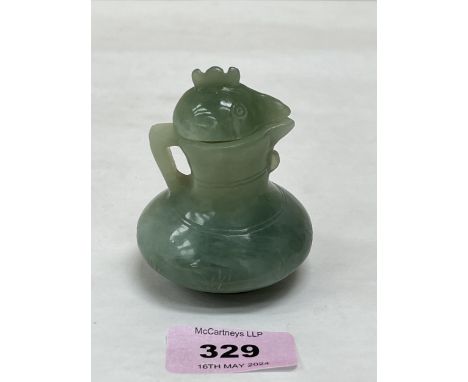 A Chinese green jade jug and cover, carved in the form of a cockerel. 3" high.