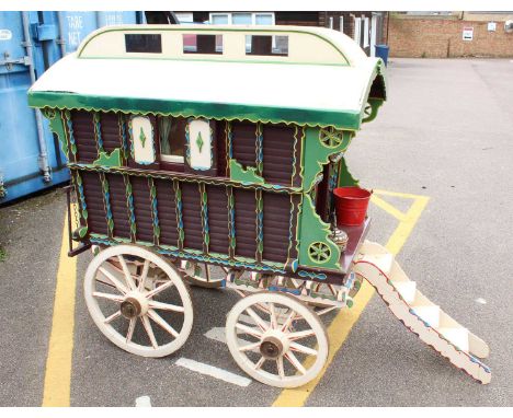 A very well made model of a approximately quarter scale travelling caravan, finished in cream, green and maroon, with nicely 