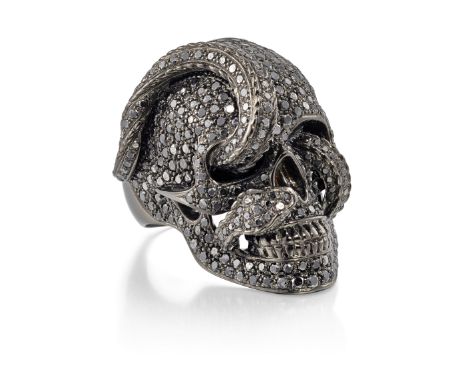 Theo Fennell. A black diamond skull ring, realistically modelled as a skull with interwoven snake, pavé set with brilliant-cu