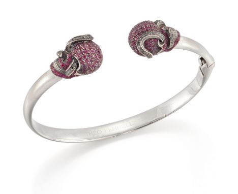 Theo Fennell. A ruby and black diamond skull bangle, of hinged torque design, with confronting skull and serpent form termina