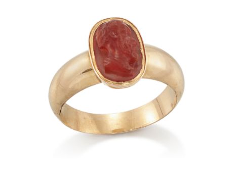An early 19th century gold cornelian cameo ring, in the Roman style with central carved oval cameo depicting a classical head