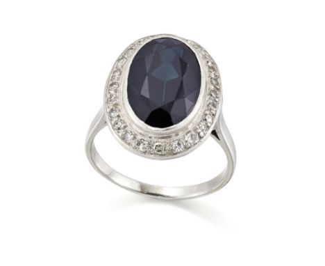 An oval sapphire and diamond cluster ring, the single oval collet-set dark blue-green sapphire within single-cut diamond surr