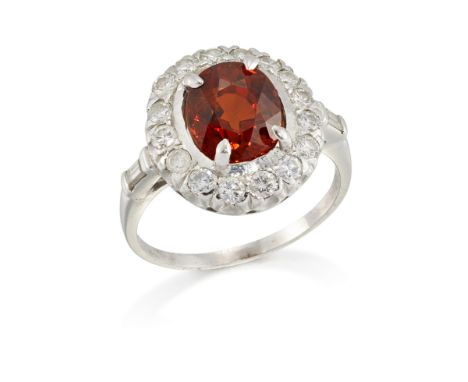 An orange garnet and diamond cluster ring, the single cushion-shaped orange garnet, approximately 9.3 x 8.0 x 6.6mm, in four-