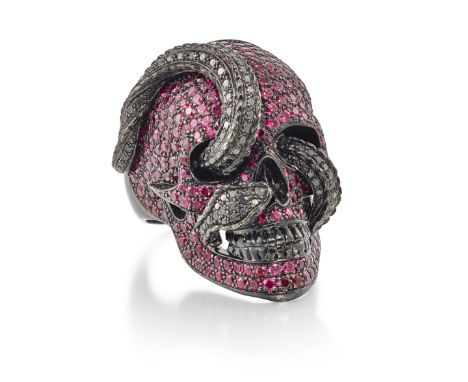 Theo Fennell. A ruby and black diamond skull ring, realistically modelled as a skull with interwoven snake, pavé set with rou