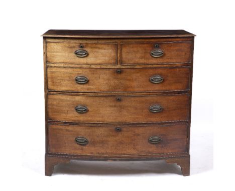 A GEORGE III MAHOGANY BOW FRONTED CHEST OF TWO SHORT AND THREE LONG DRAWERS with oval brass handles and standing on bracket f