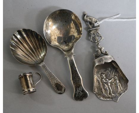 A Georgian silver caddy spoon, two later caddy spoons and a miniature mug.