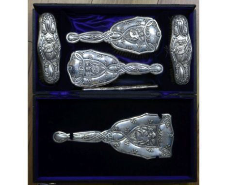 An Edwardian Art Nouveau repousse silver six piece brush and mirror set, by Levi & Salaman, Birmingham, 1904, in Coombs Ltd, 