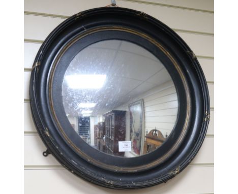 A circular ebonised wall mirror W.59cm