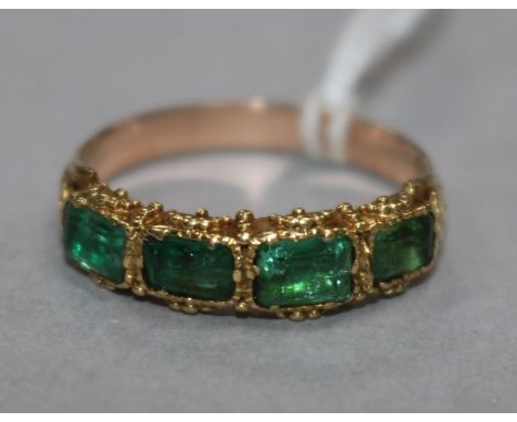 A yellow metal and four stone emerald half hoop ring (one stone replaced?), size N.