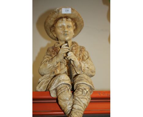 A LARGE BRETBY STYLE SEATED SHELF EDGE FIGURE OF A BOY PLAYING A PENNY WHISTLE  