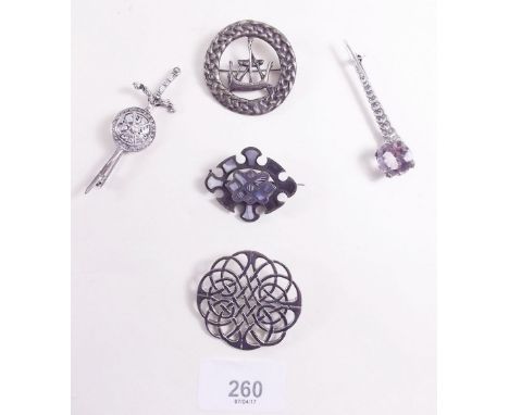 A Scottish silver viking boat brooch, a silver Celtic design brooch,  a silver dagger brooch, a silver brooch set purple ston