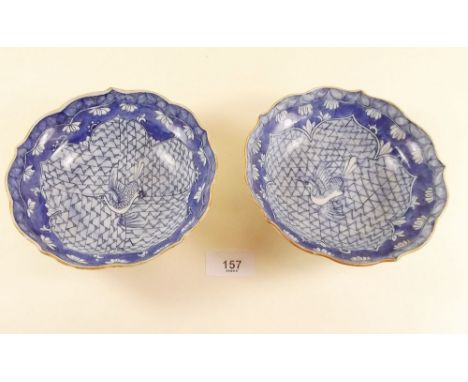 A pair of 18th century Chinese saucers painted birds on decorative panels, both with hairline cracks