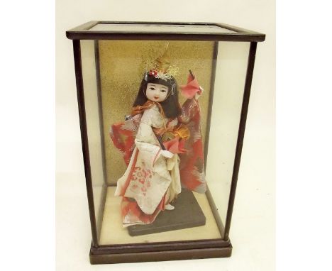 chinese doll in glass case