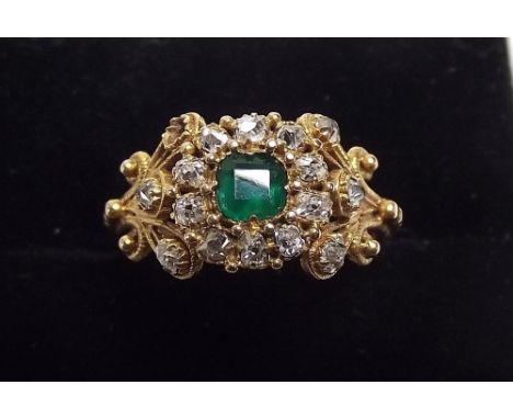 A fine early 19th century emerald and diamond cluster ring the emerald within 10 old cut diamond surround on filigree and dia