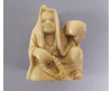 A Japanese early 20th century carved ivory netsuke in form of a seated man 