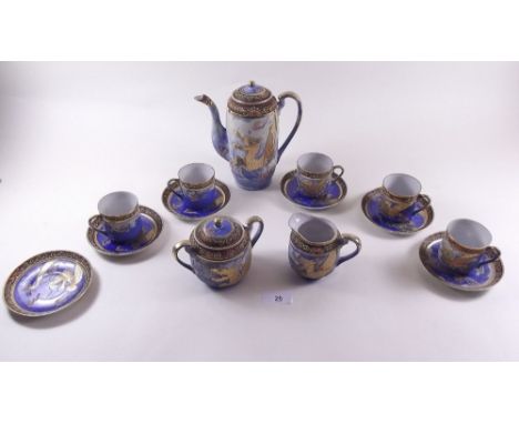 A Japanese Satsuma coffee set comprising: coffee pot, milk, sugar, four cups and saucers, decorated dragons on a blue ground 