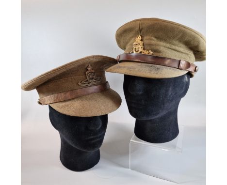 Two WWI period Officer's caps with cap badges for Royal Artillery. (2) (Mannequin head for display only) (B.P. 21% + VAT)
