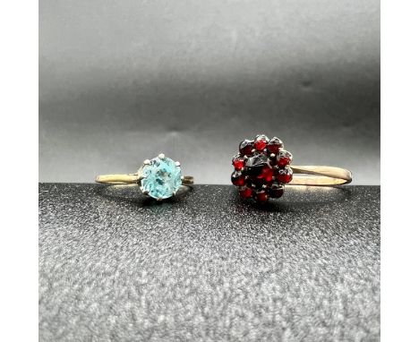 2x 9ct yellow gold dress rings,
one is a blue cz stone which is unhallmarked and size K,
one is a dark garnet stone which is 