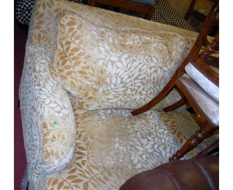 A Victorian style floral upholstered three seater sofa, raised on turned forelegs to brass cup castors