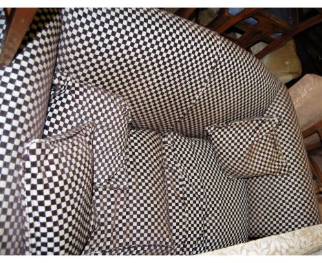 A Victorian style chequer upholstered two seater sofa, raised on turned forelegs to cup castors with scatter cushions