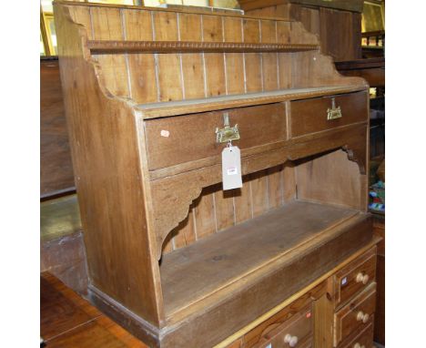 A small beech and pine dresser base, having integral raised shelf over tiwn frieze drawers, to lower plinth, w.118cm