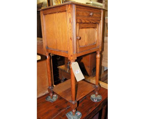 A late Victorian pitched pine and white marble topped single door pot cupboard having ceramic lined interior, with single upp