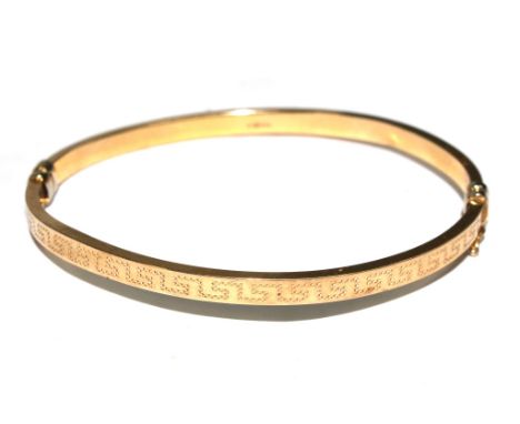 A 9 carat gold bangle decorated with Greek key pattern