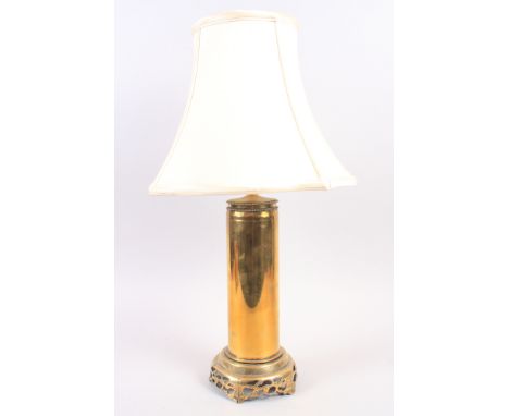A brass shell case lamp and shade, 12" high