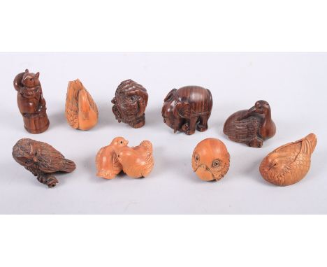 Nine carved hardwood netsuke, in the form of various animals with black glass eyes