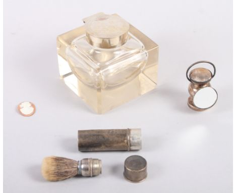 A silver topped glass inkwell, a silver cased shaving brush, a pin cushion, in the form of a car lamp, and a loose cameo