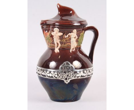 A Portuguese jug and cover, decorated with figures and pierced silver band and inscription "turn around and drink well", 10" 