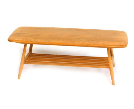 An Ercol light elm coffee table, the rectangular top with a rounded edge, above a slatted under tier, on cylindrical tapering