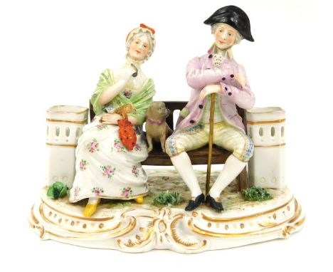 A Continental porcelain figure group, of two figures seated on a bench, depicting a lady and gentleman with a pug, 15cm high,
