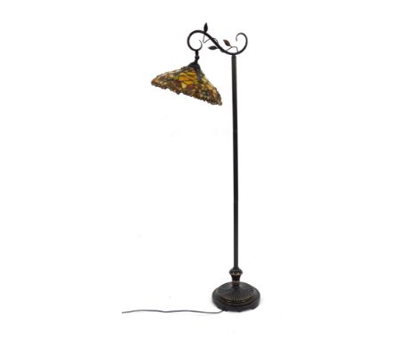 A Tiffany style standard lamp, the conical shade decorated in oranges, reds, etc, with applied stone decoration, 151cm high.