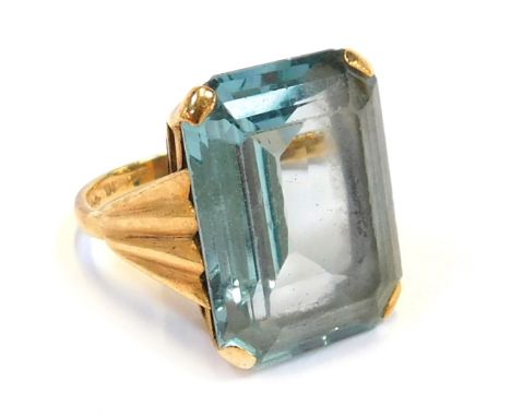 A 9ct gold dress ring, with rectangular cut light blue stone, in a raised basket with fluted design shoulders, ring size K½, 