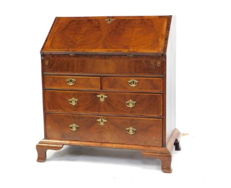A George III oak bureau, the fall opening to reveal a central semi-secret drawer and two sliding column compartments, flanked