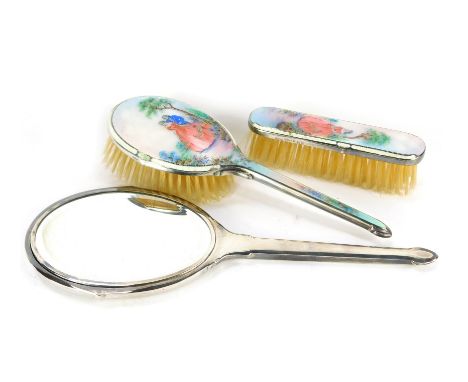 A George VI silver and white guilloche enamel three piece dressing table set, painted with a gallant and lady, in a garden se
