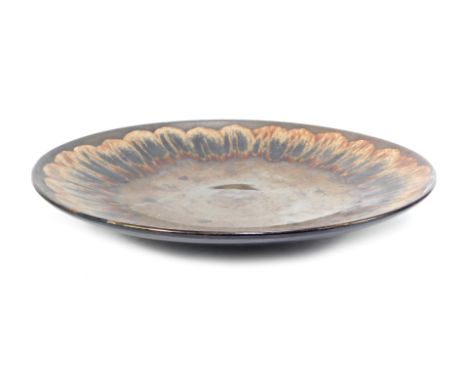 A Poole Pottery charger, decorated with brown and black repeating pattern, against a lustre brown ground, 40cm diameter.