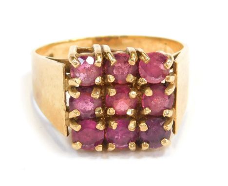 A 9ct gold dress ring, the square set panel with nine garnets, each in claw setting, on a plain yellow metal band, R, 5.7g al