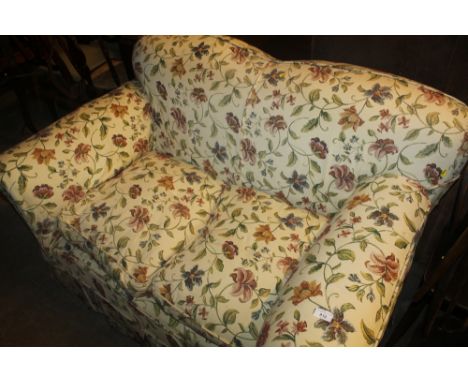 AN UPHOLSTERED TWO SEATER SOFA