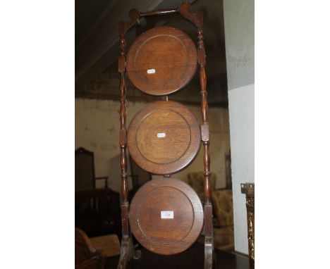 A THREE TIER DUMB WAITER TOGETHER WITH A OAK BOOK TROUGH