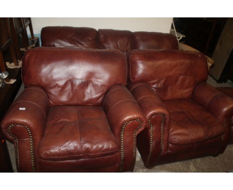 A BROWN LEATHER THREE PIECE SUITE AND A POUFFE