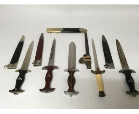 A group of five German daggers with scabbards, and one spare scabbard for a reproduction dagger.